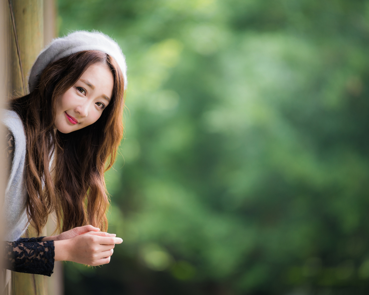 Азиатка в берете выглядывает из окна