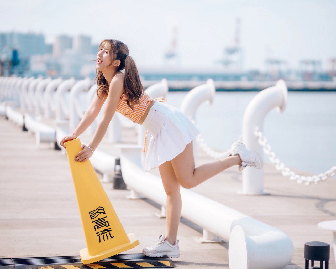 Азиатка с короткой белой юбке у воды 