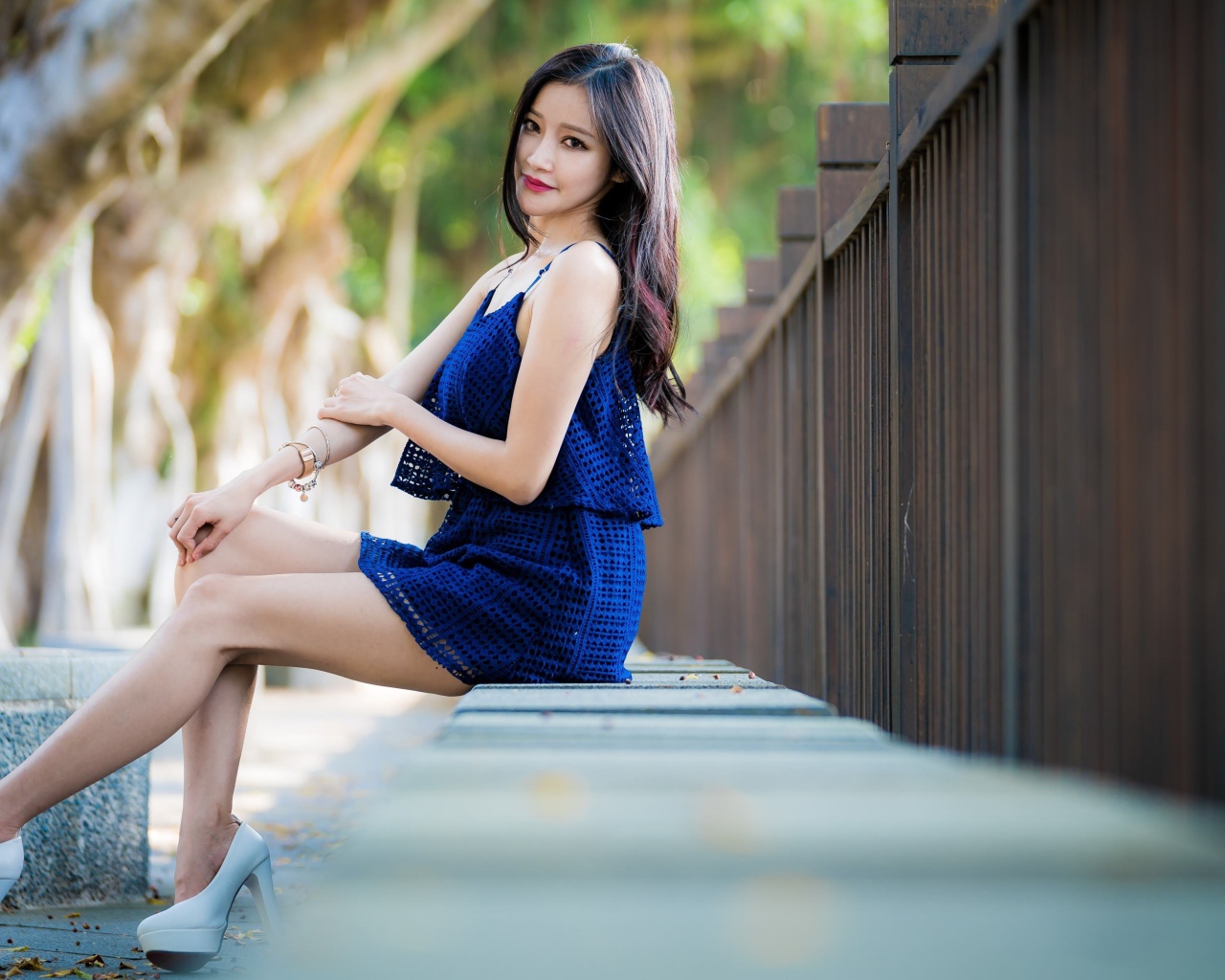 Красивая девушка азиатка в синем платье в парке