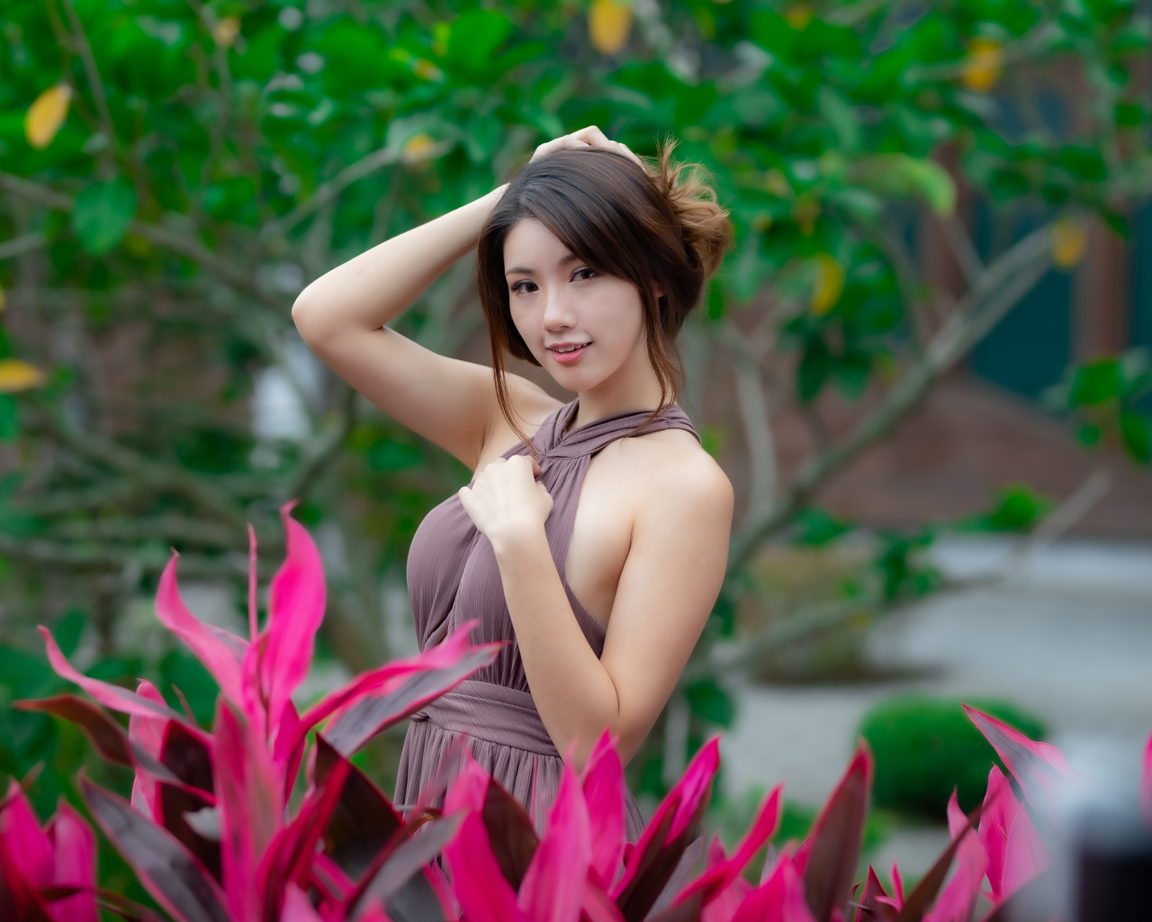 Красивая девушка азиатка в платье у красных цветов