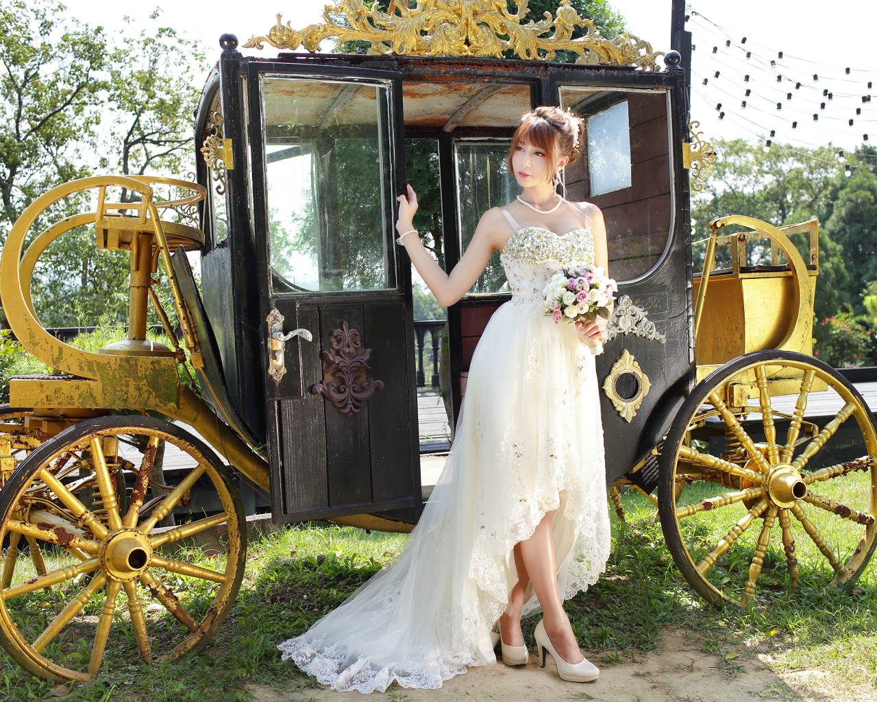 Красивая девушка азиатка в свадебном платье у кареты 