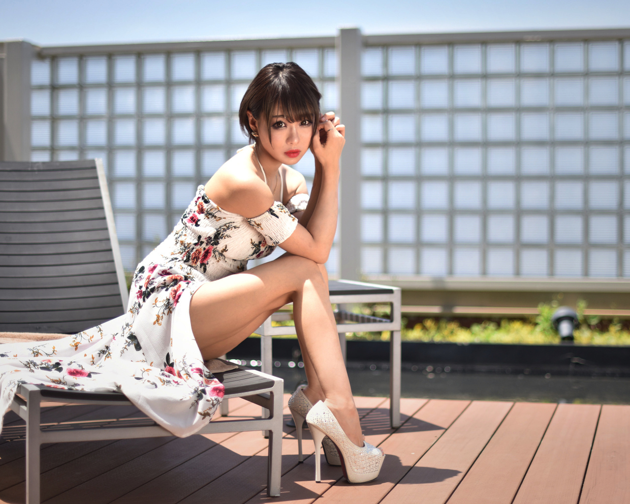 Красивая девушка азиатка сидит на шезлонге 