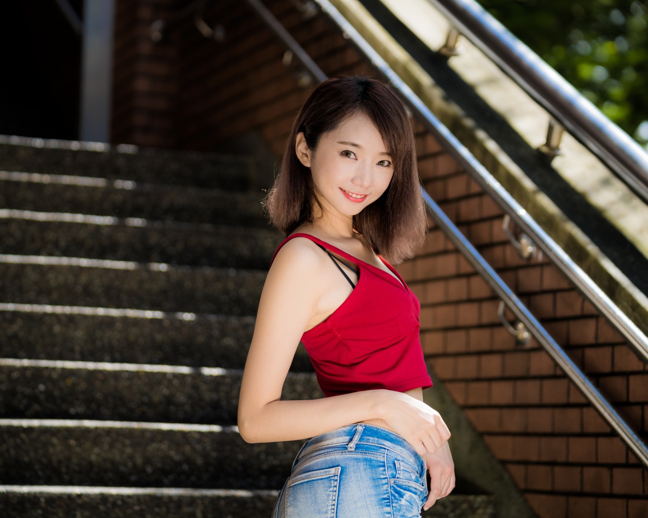 Красивая девушка азиатка стоит на ступенях 