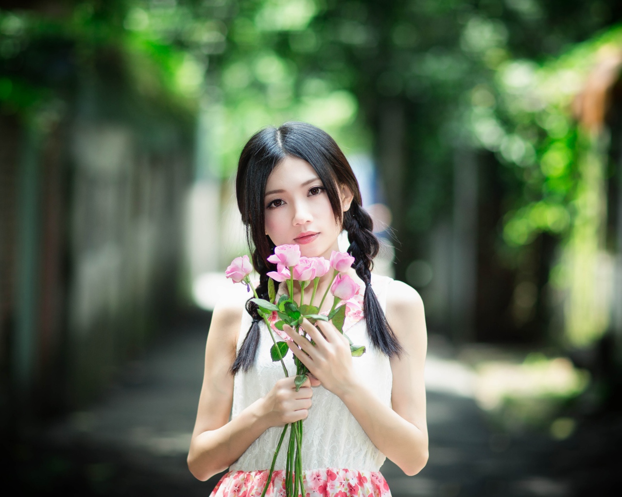 Красивая девушка азиатка в букетом роз в руках