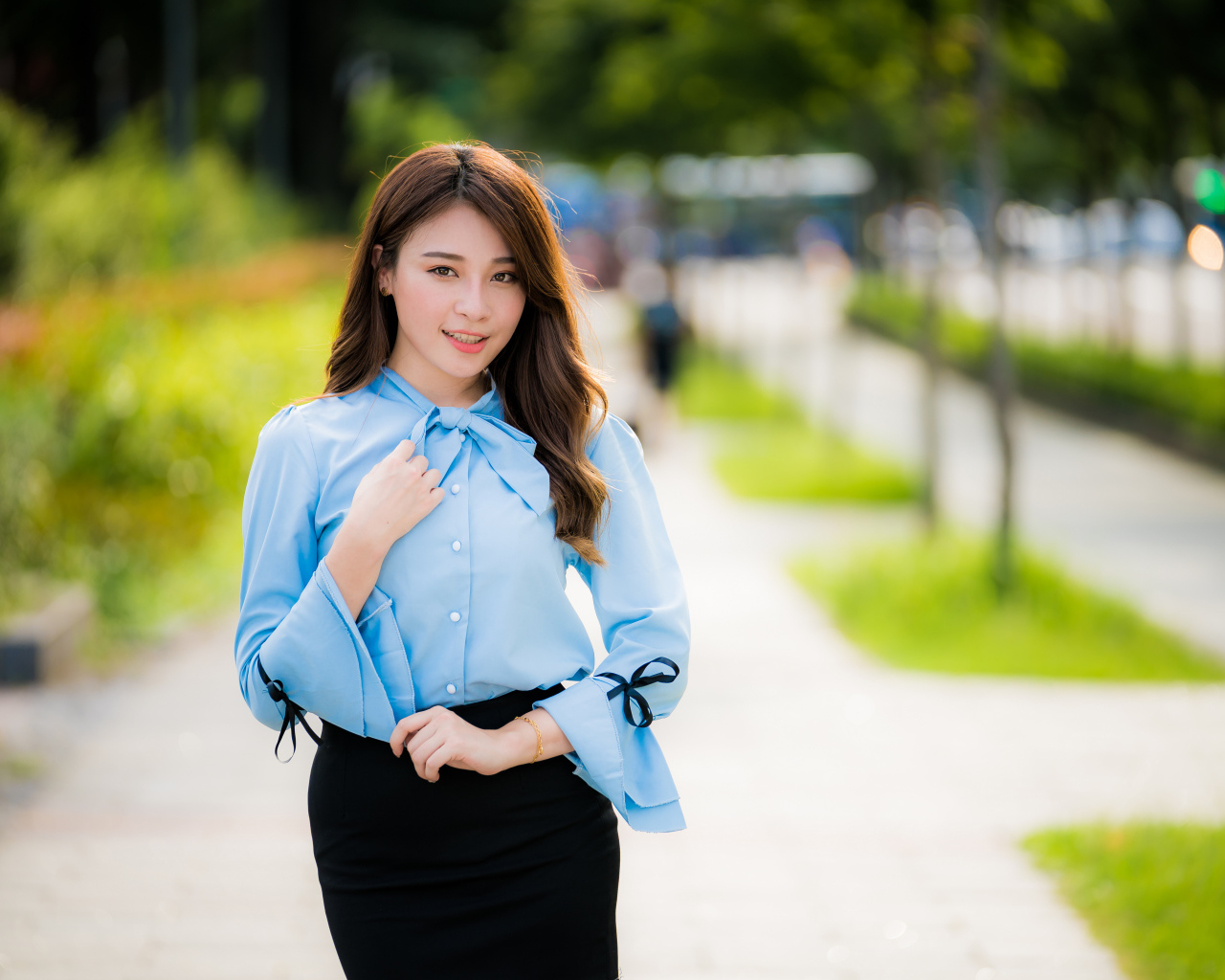 Красивая азиатка в голубой блузке и черной юбке 