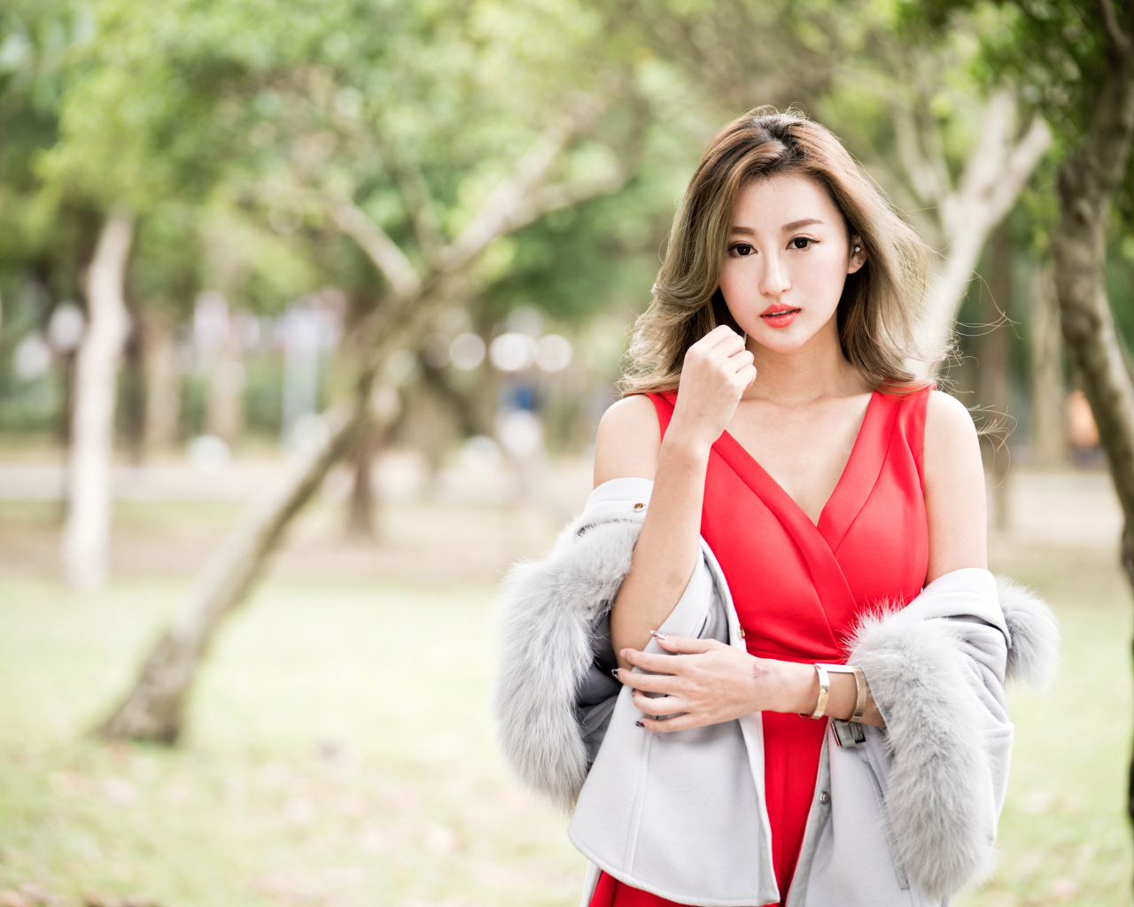 Красивая азиатка в красном платье в парке