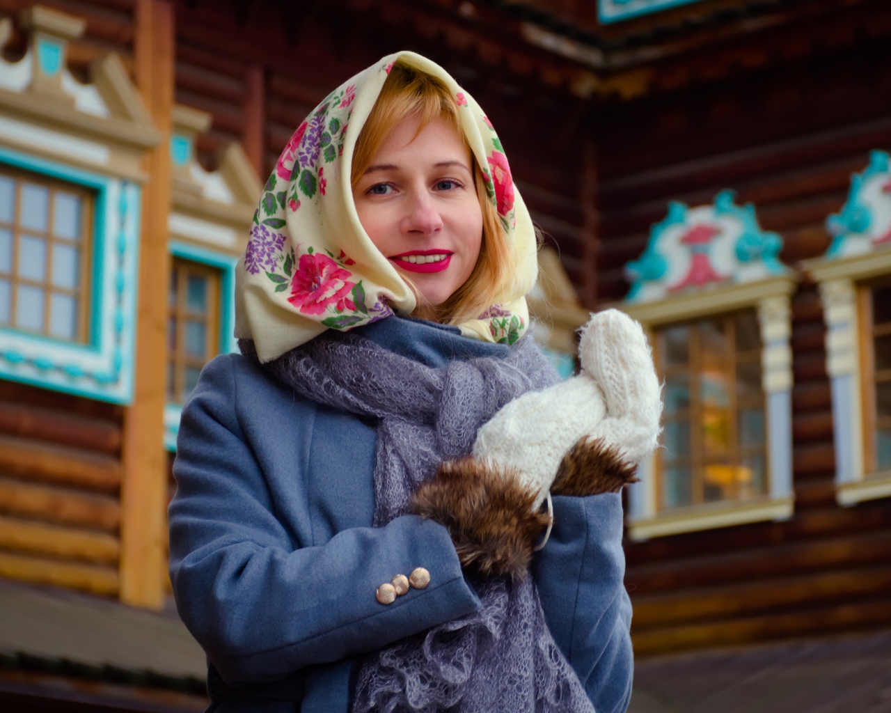 Красивая русская женщина в платке стоит у дома