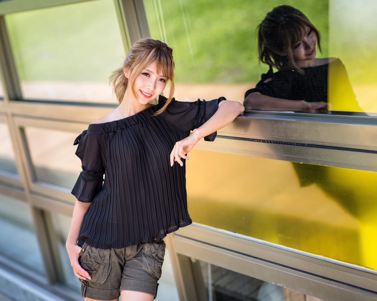 Красивая девушка азиатка в черной блузке у окна