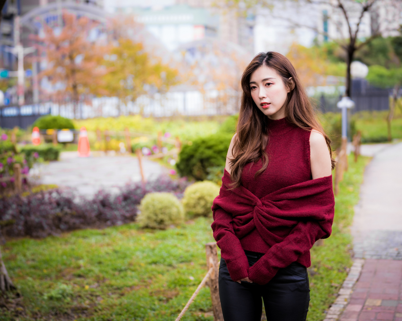 Красивая девушка азиатка в красном наряде в парке