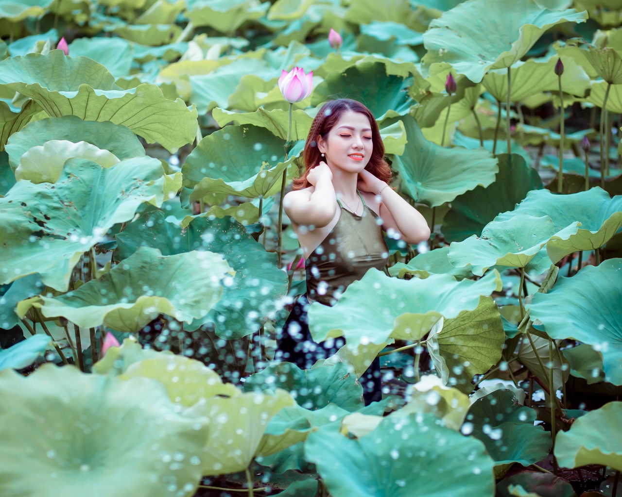 Красивая девушка азиатка в зеленых листьях лотоса 