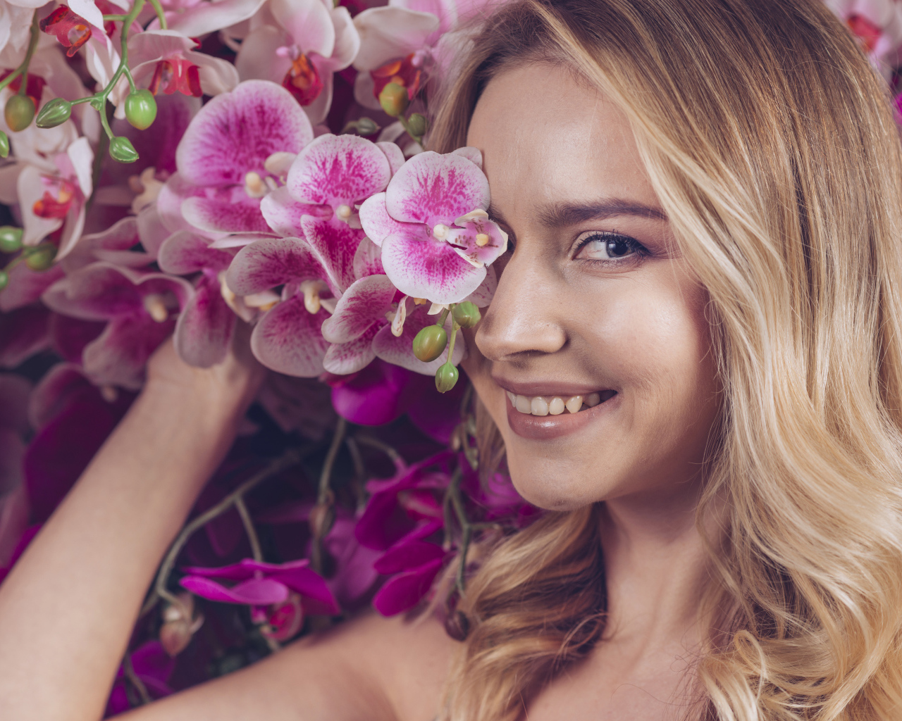 Красивая девушка блондинка с цветами орхидеи