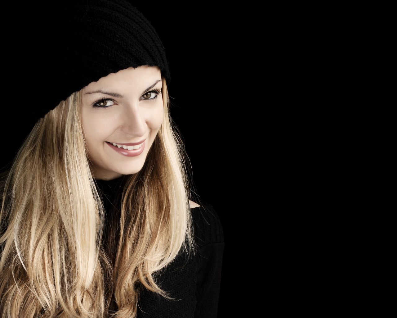 Красивая блондинка в шапке на черном фоне