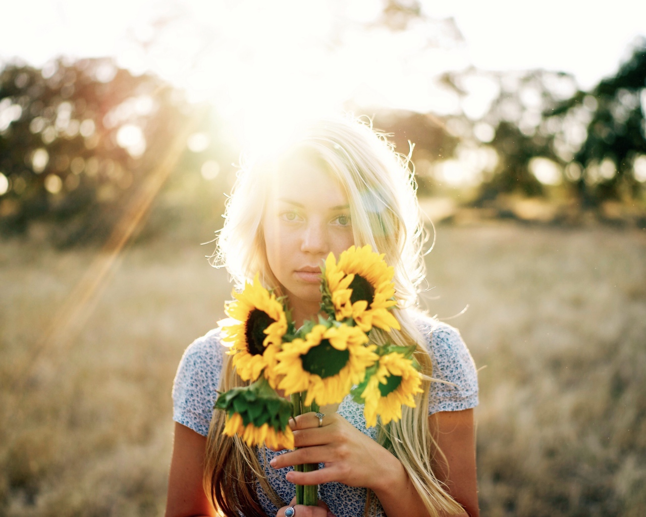Красивая блондинка с букетом подсолнухов в руках