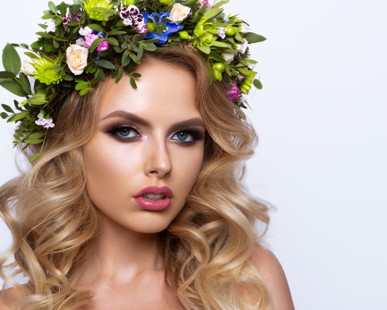 Красивая блондинка с венком из живых цветов на белом фоне