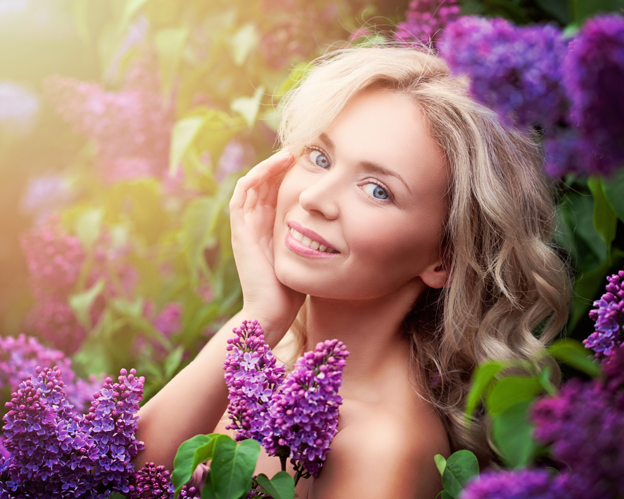 Красивая голубоглазая девушка блондинка в цветах сирени