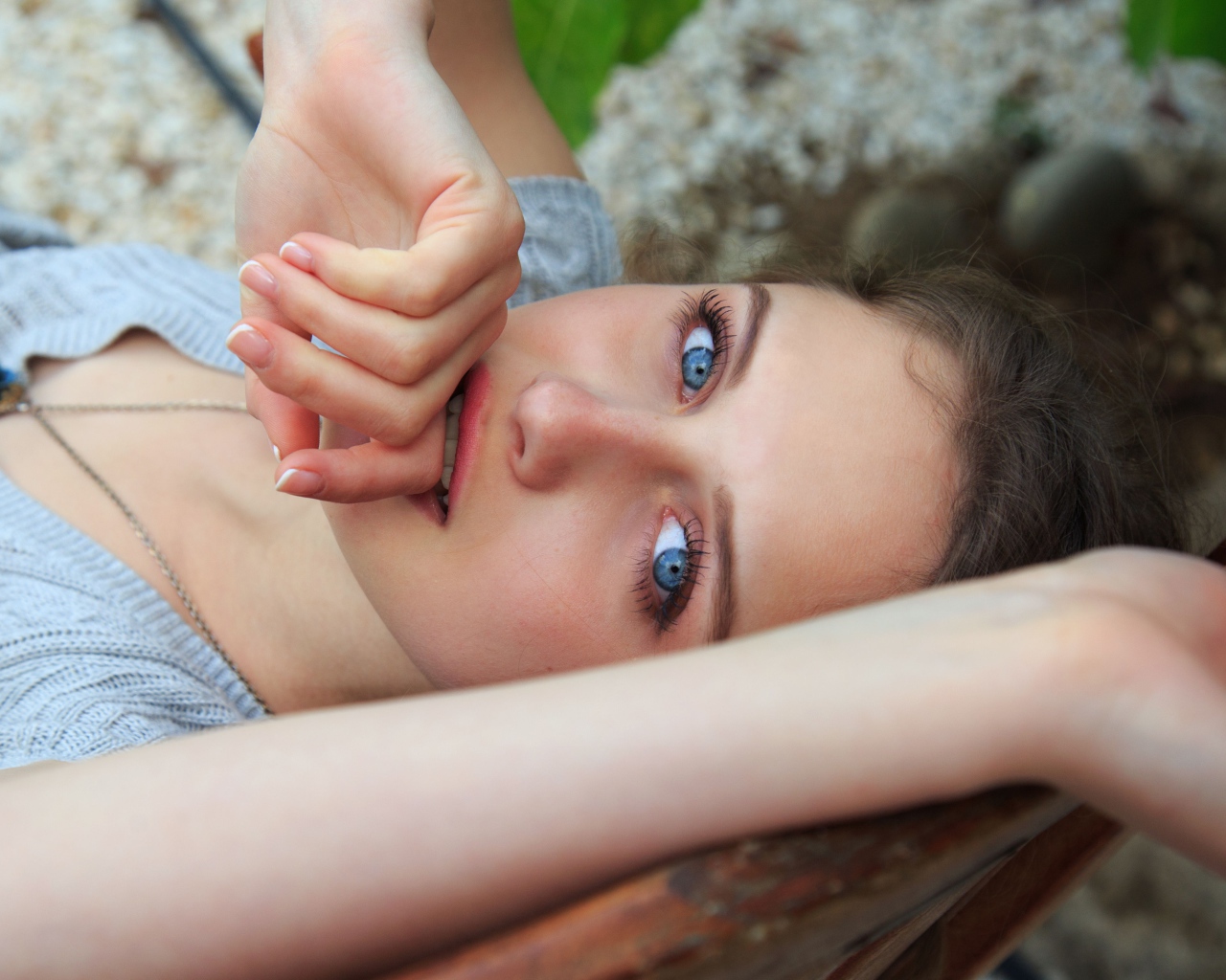 Красивая голубоглазая девушка с рукой у рта