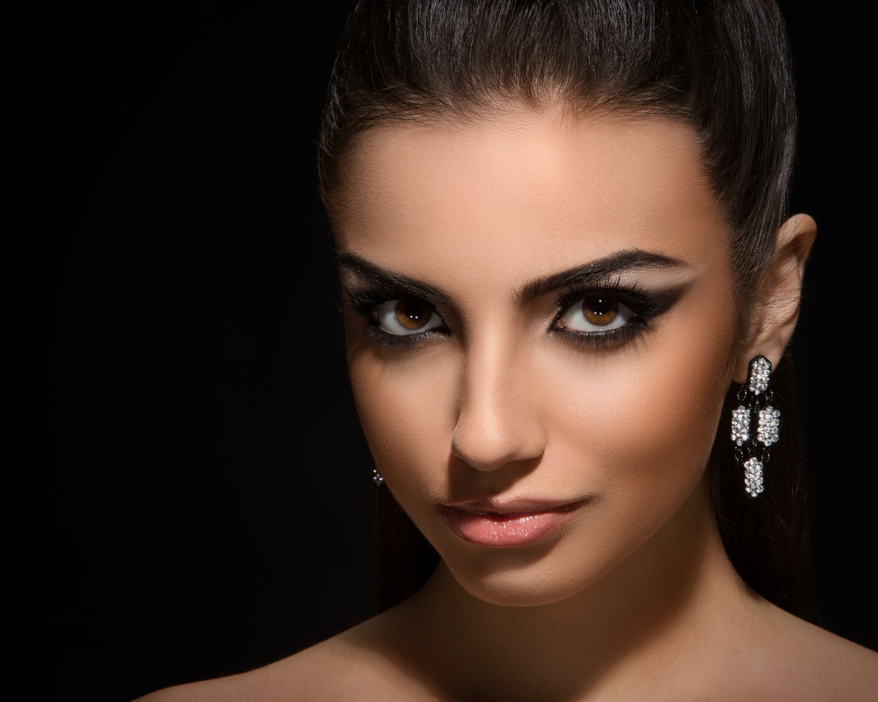 Красивая кареглазая девушка с прической на черном фоне