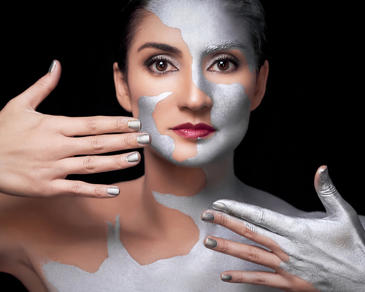 Красивая кареглазая женщина с серебристой краской на теле 