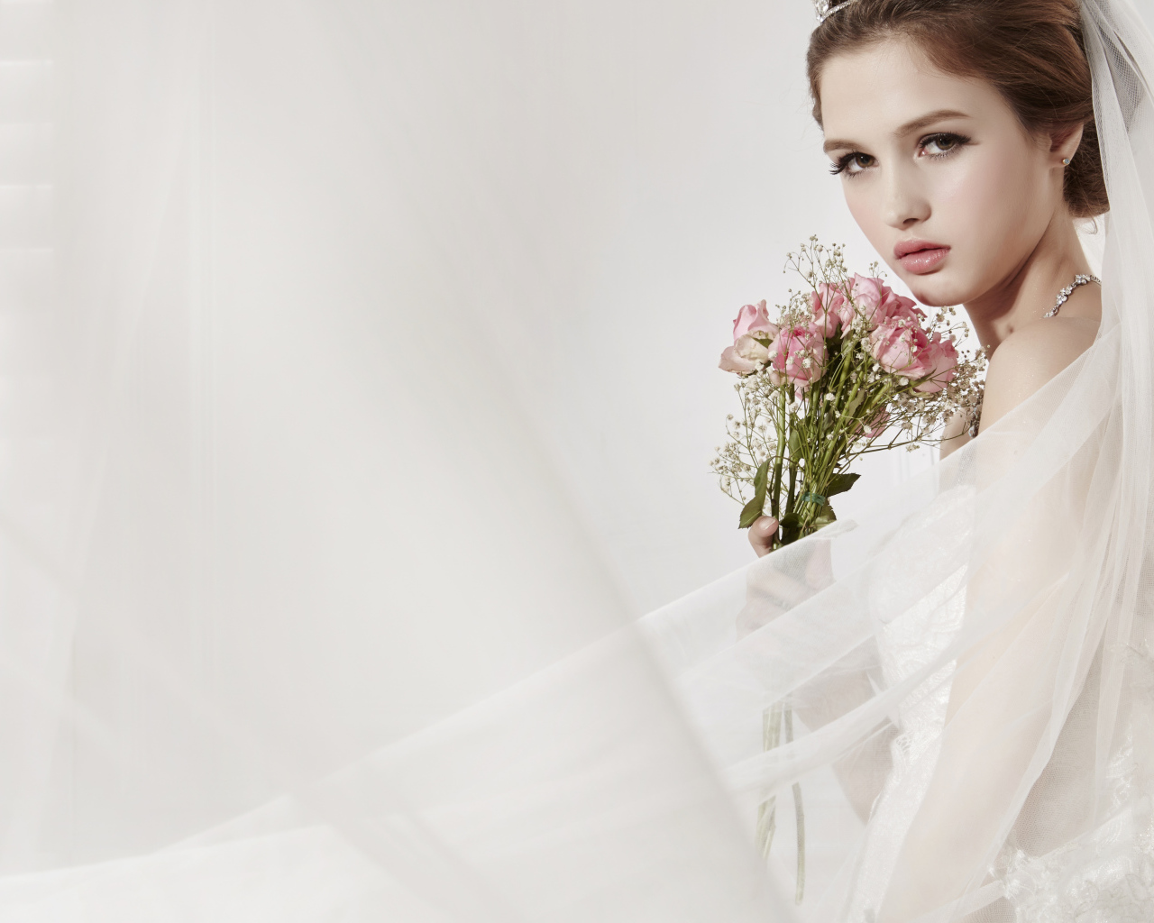 Красивая девушка невеста в свадебном платье с букетом роз 