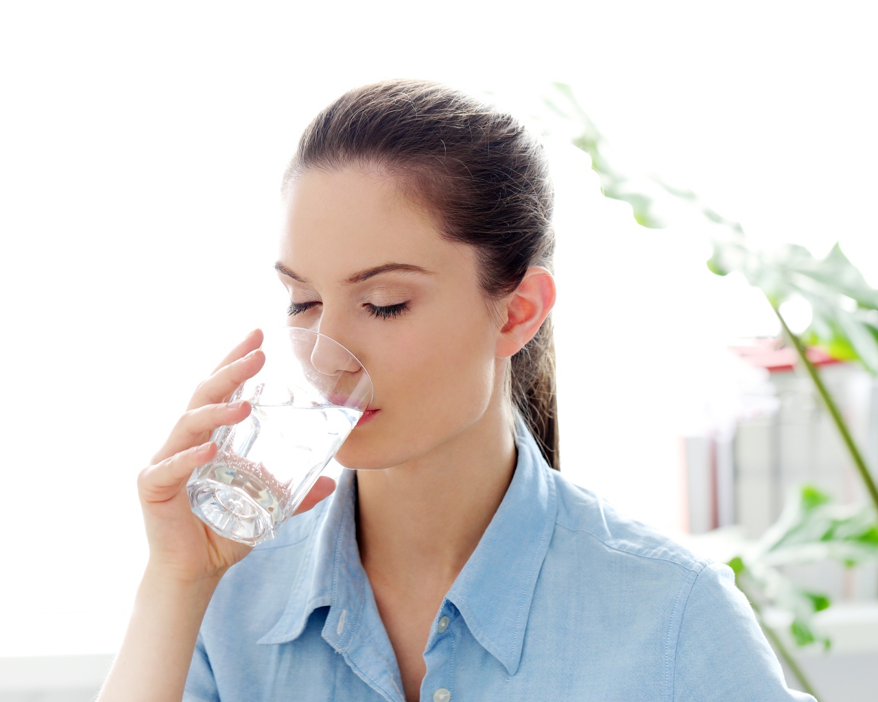 Красивая девушка пьет воду утром
