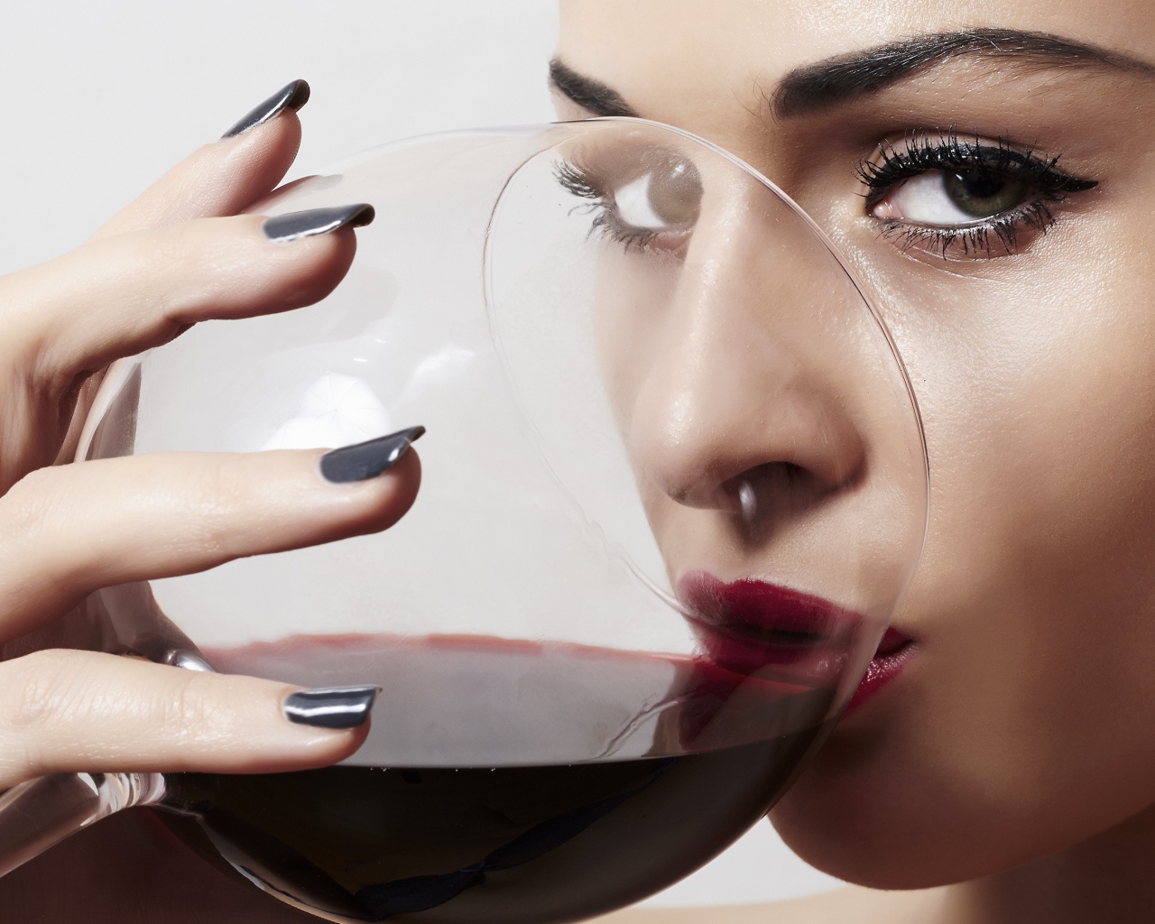 Красивая девушка пьет вино из бокала 