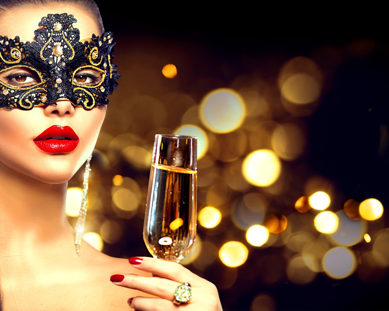 Красивая девушка в черной маске с бокалом шампанского