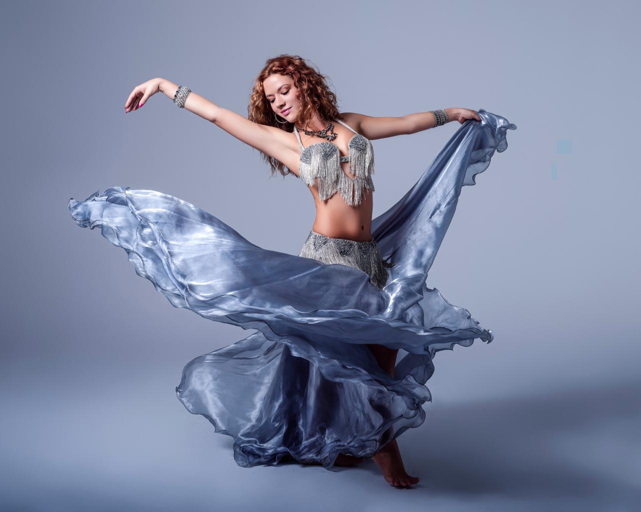 Красивая девушка в платье для танцев на сером фоне