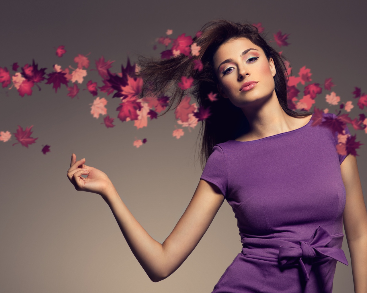 Красивая девушка в фиолетовом платье на сером фоне 