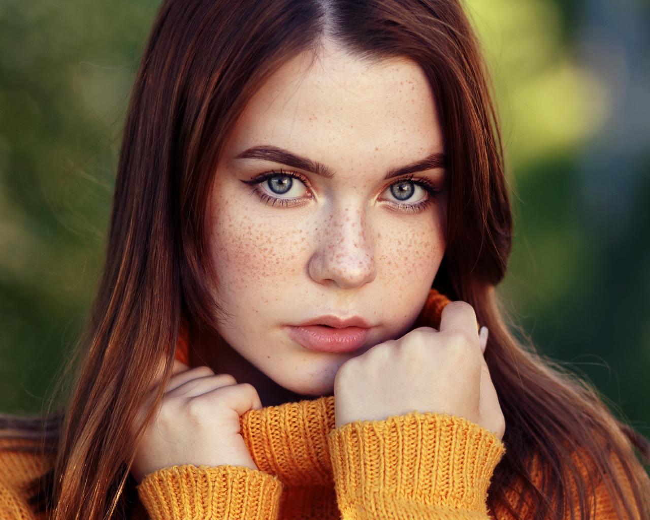 Красивая девушка в теплом свитере с веснушками на лице