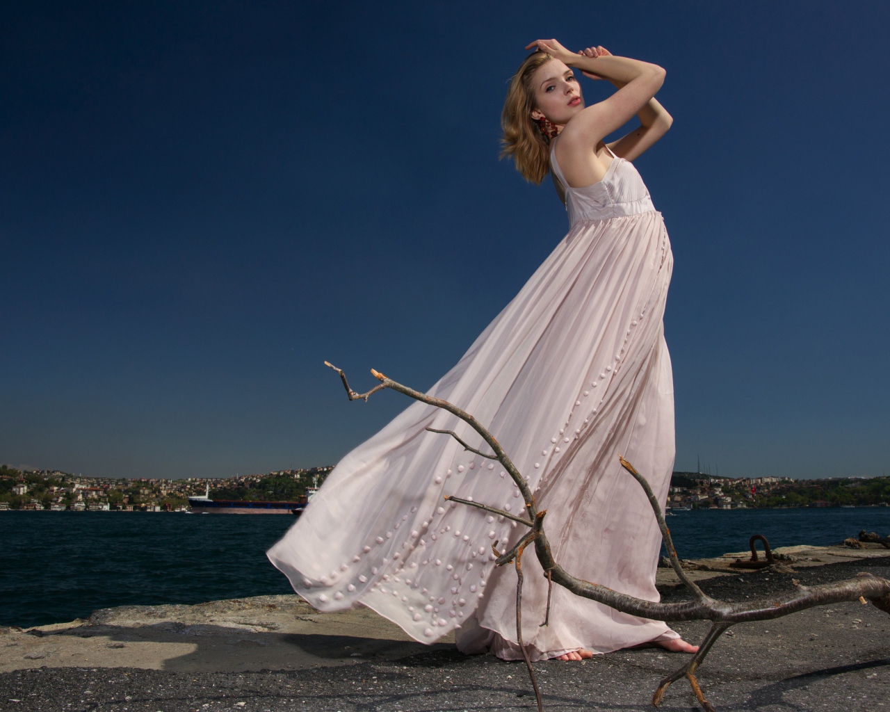 Красивая девушка в белом платье на берегу реки