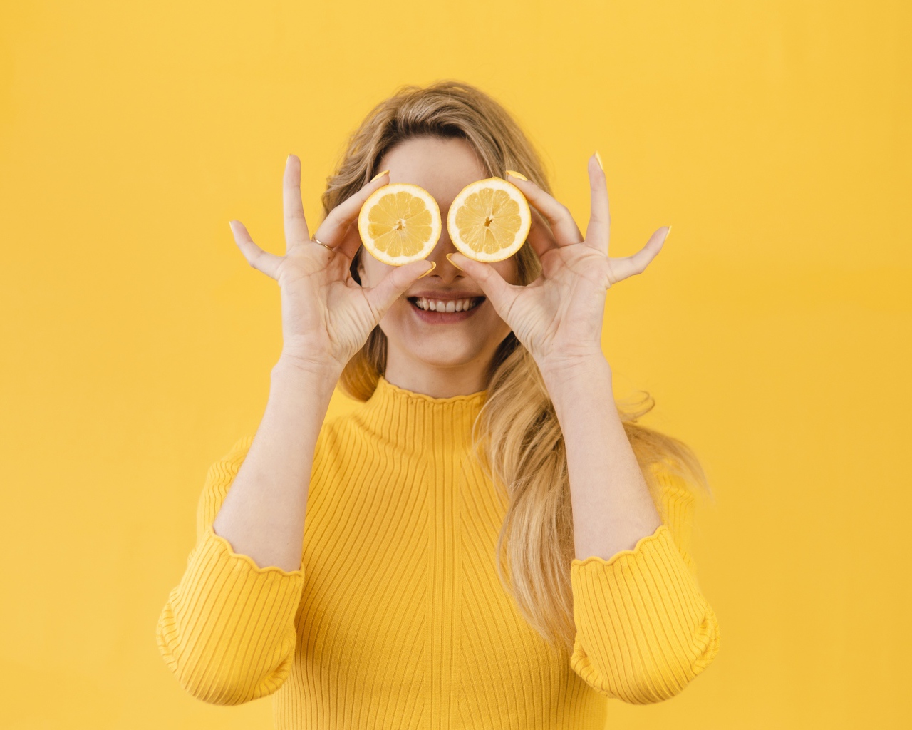 Красивая девушка в желтом свитере с лимоном
