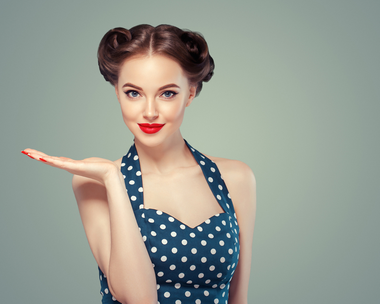 Красивая девушка в платье в горошек на сером фоне