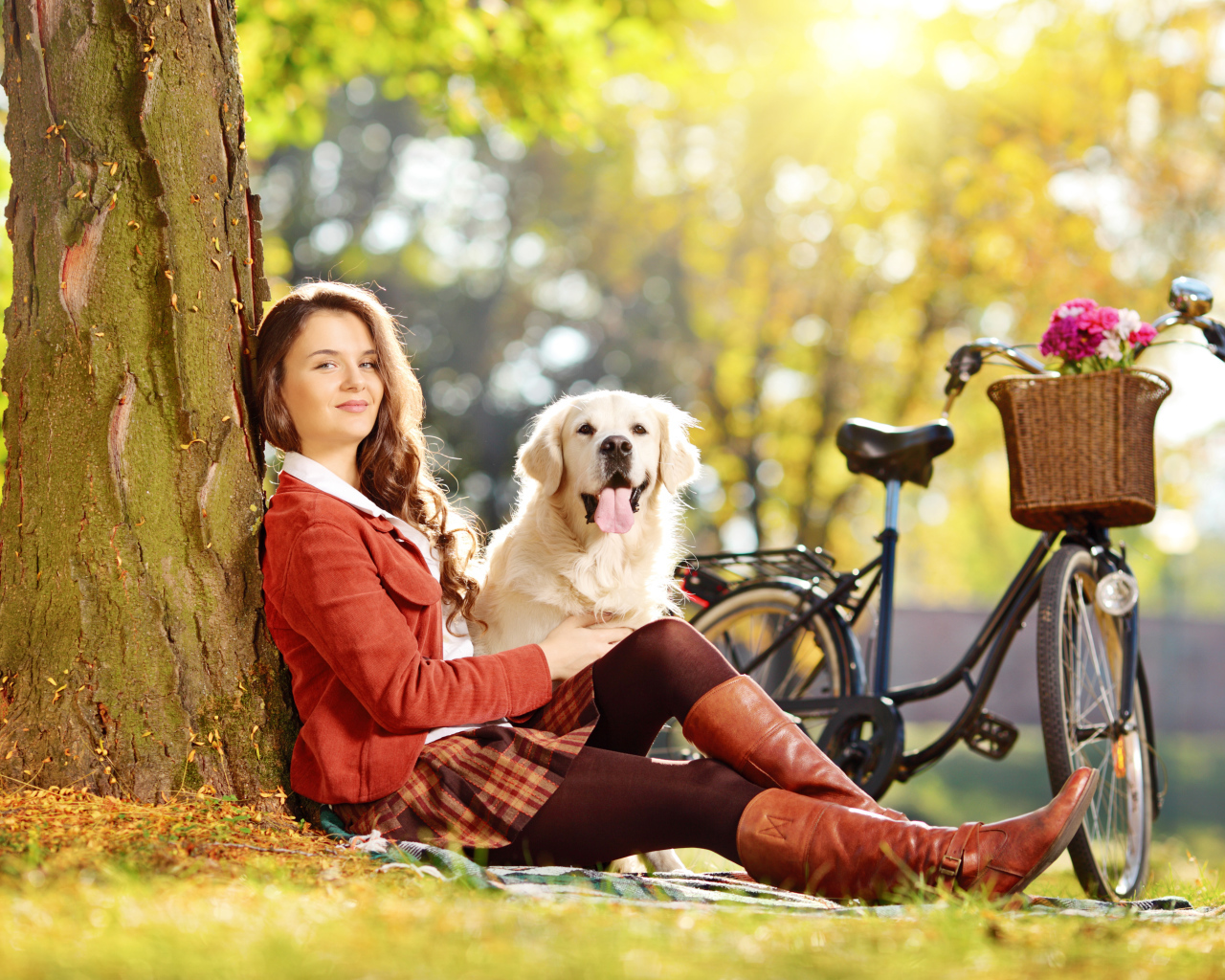 Красивая девушка сидит с собакой у дерева 