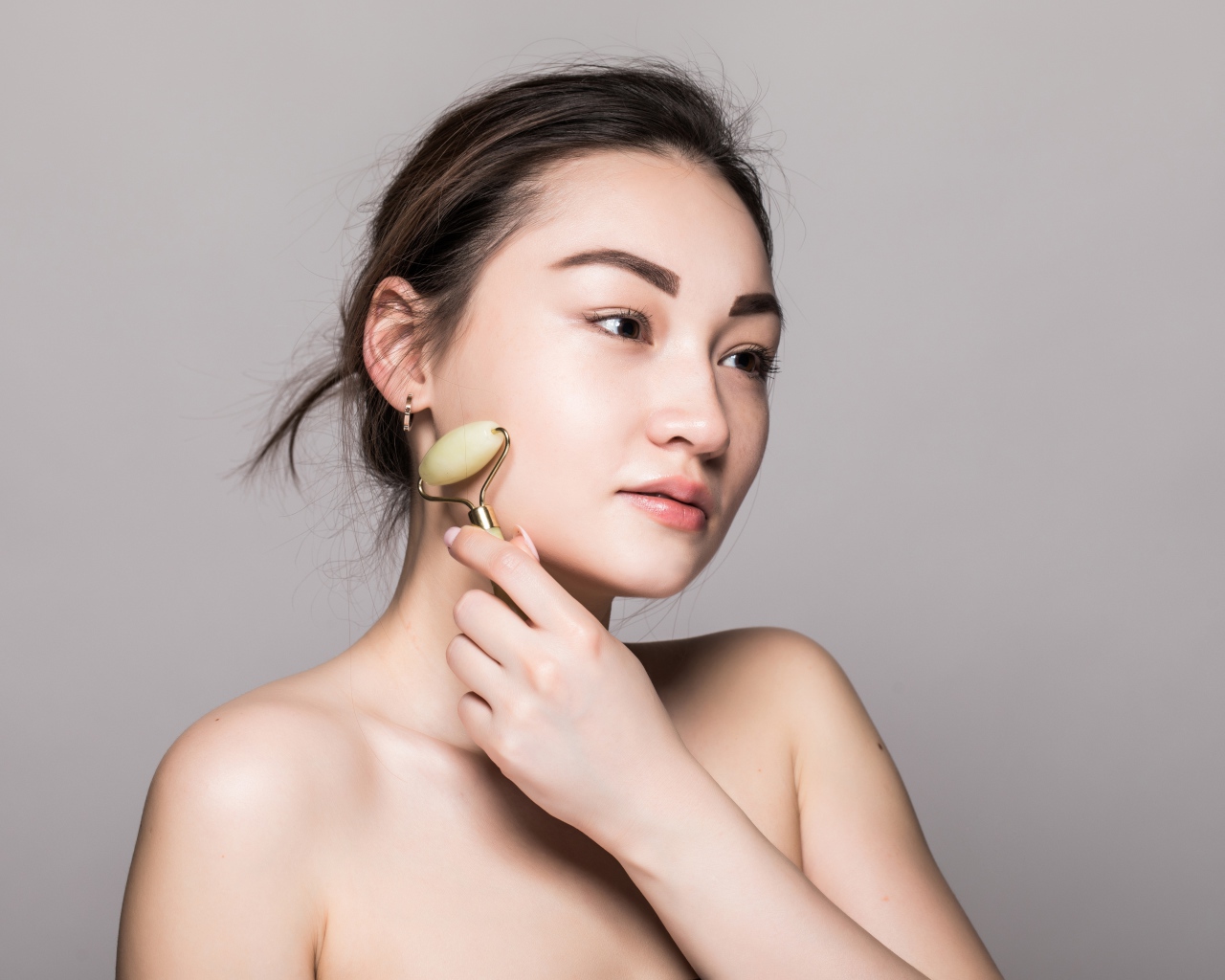 Красивая девушка разглаживает кожу лица