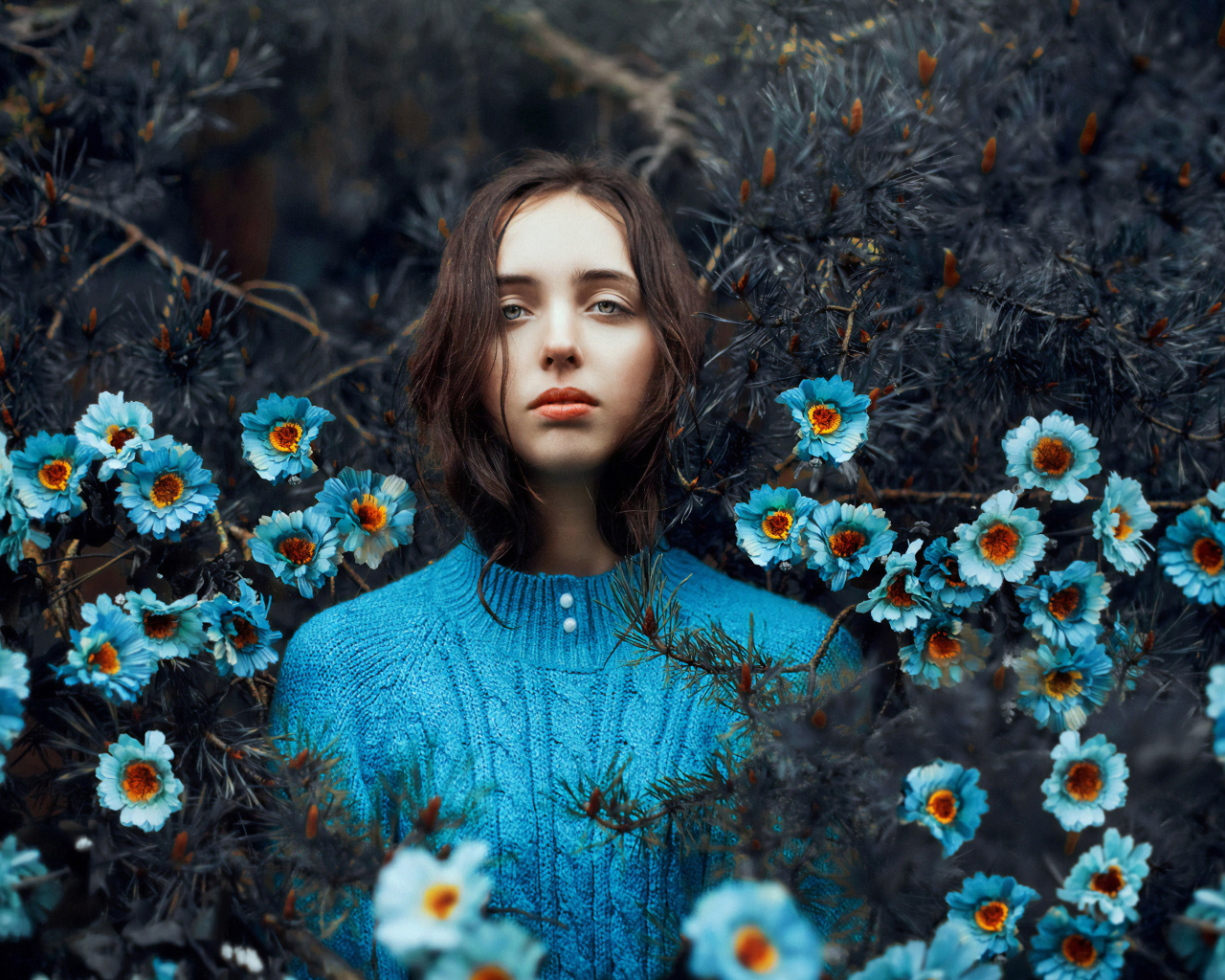 Красивая девушка колючих зарослях с голубыми цветами