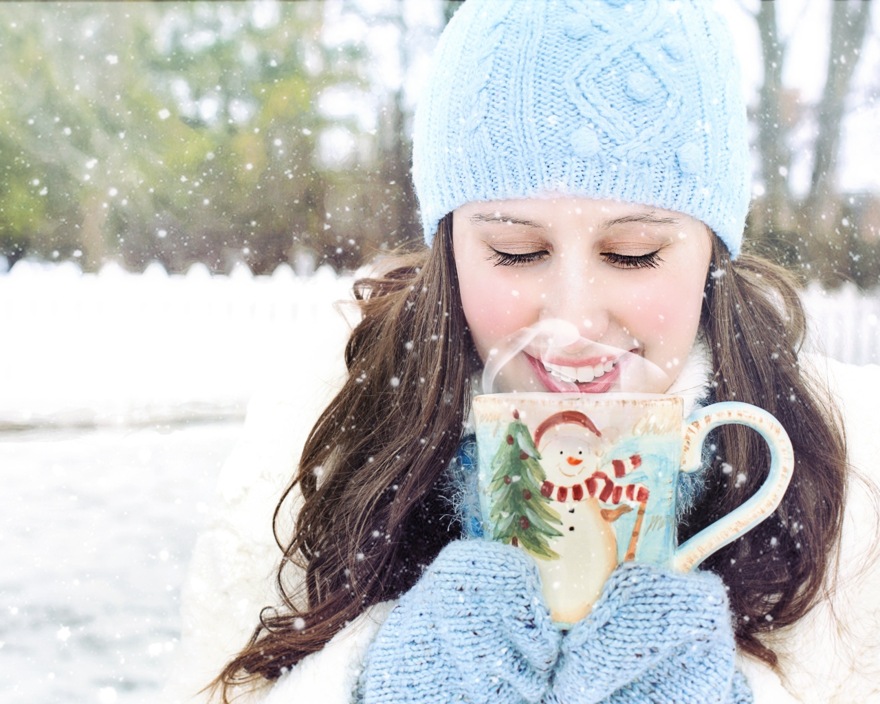 Красивая девушка с чашкой горячего кофе на улице зимой