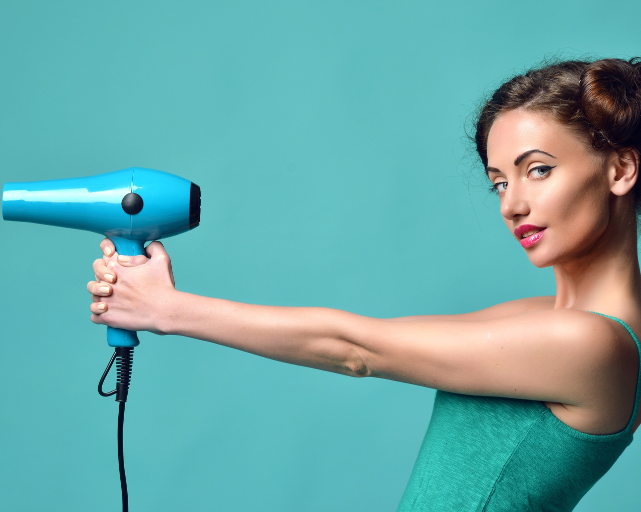Красивая девушка с феном в руках на голубом фоне