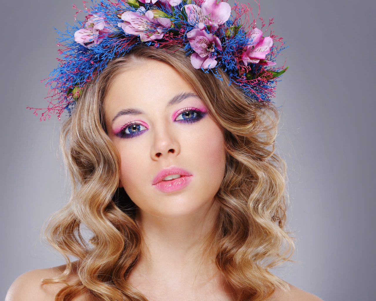 Красивая девушка с нежным макияжем с венком на голове на сером фоне