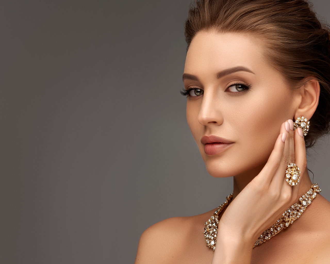 Красивая девушка с вечерней прической и дорогими украшениями
