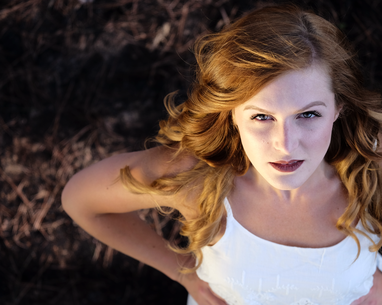 Красивый взгляд рыжеволосой девушки в белом платье