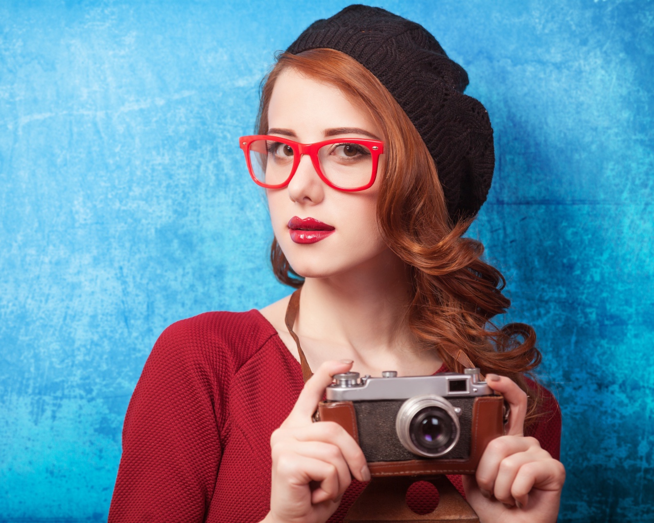 Красивая рыжеволосая девушка в черном берете с фотоаппаратом в руках 