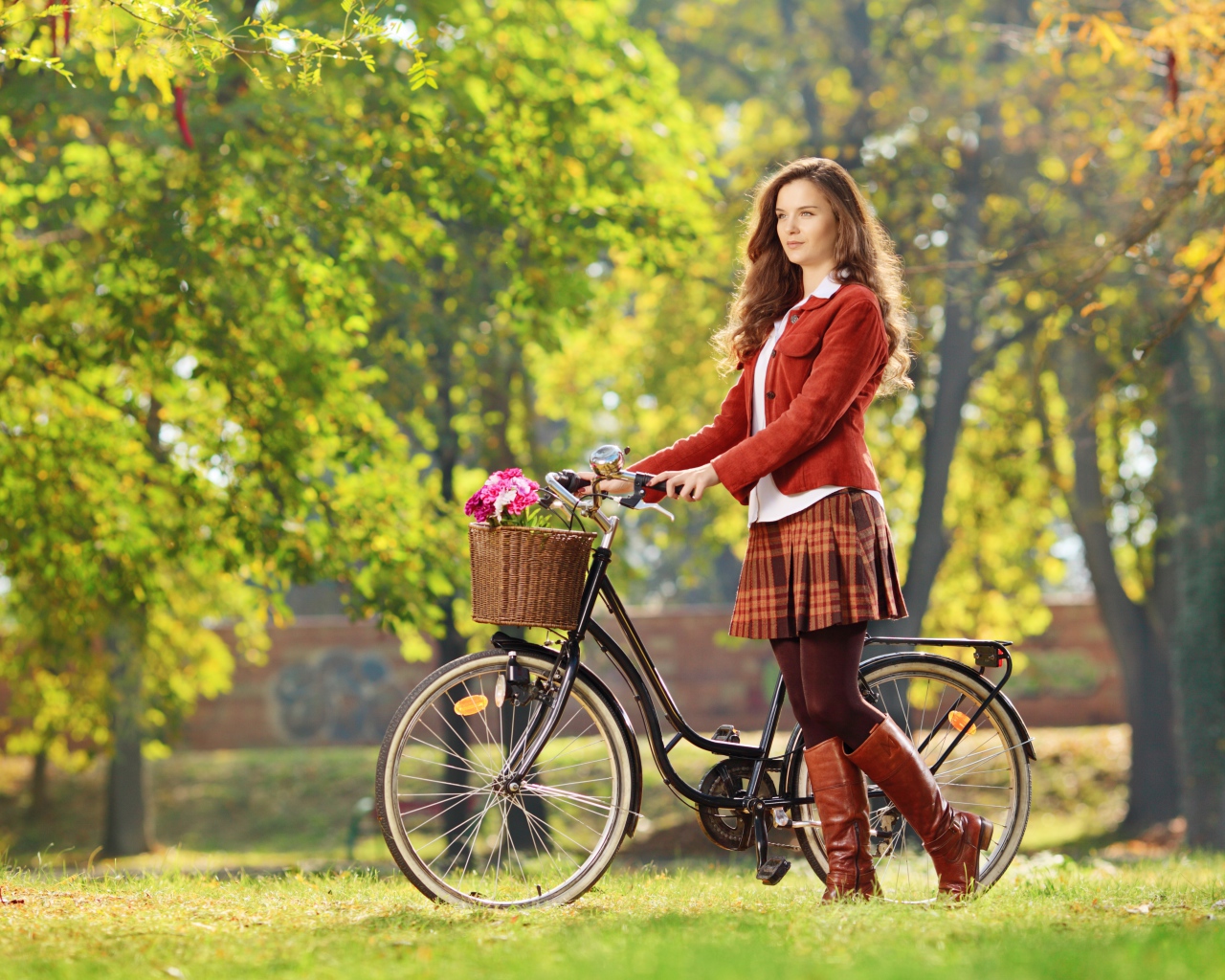 Красивая молодая девушка на велосипеде в парке 