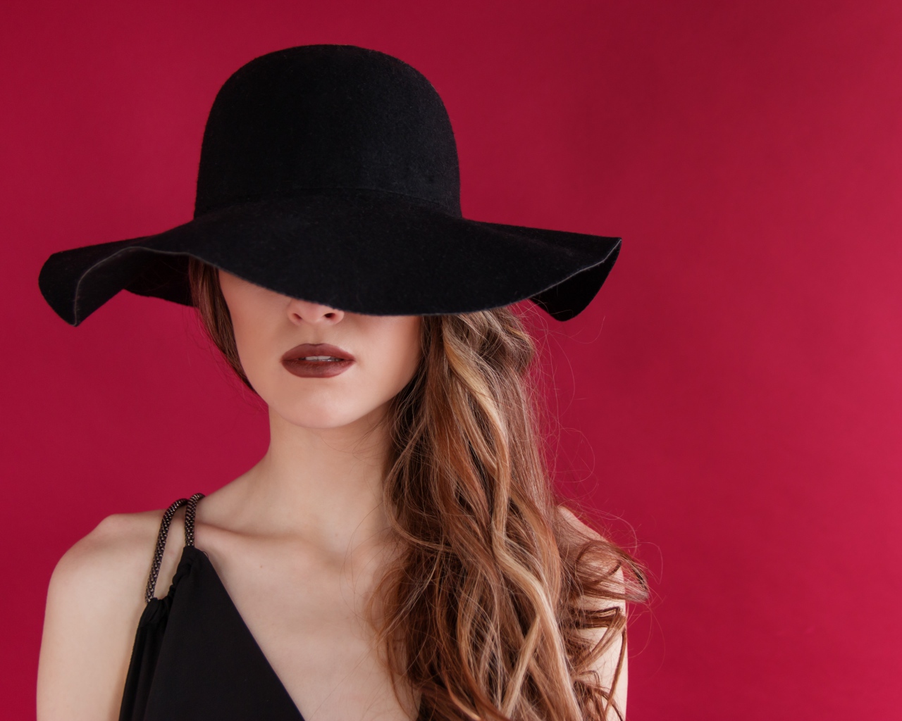Большая черная шляпа закрывает лицо девушки