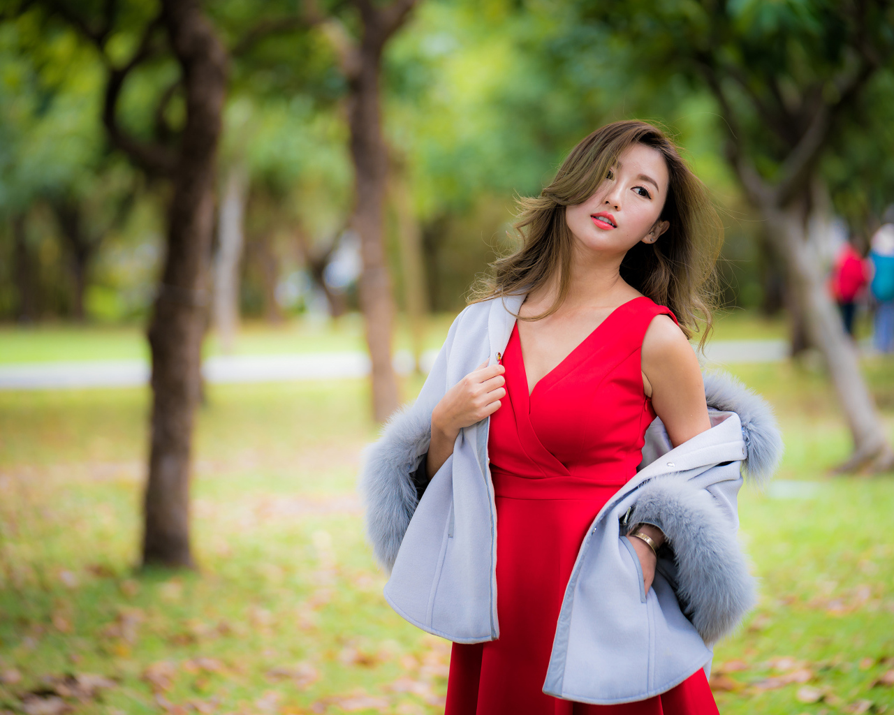 Яркая девушка азиатка в красном платье в парке