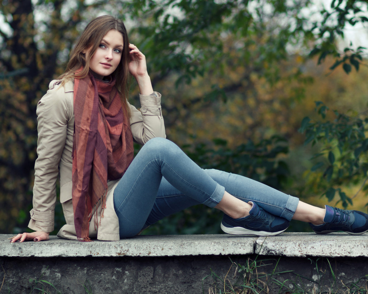 Милая девушка в куртке и синих джинсах 