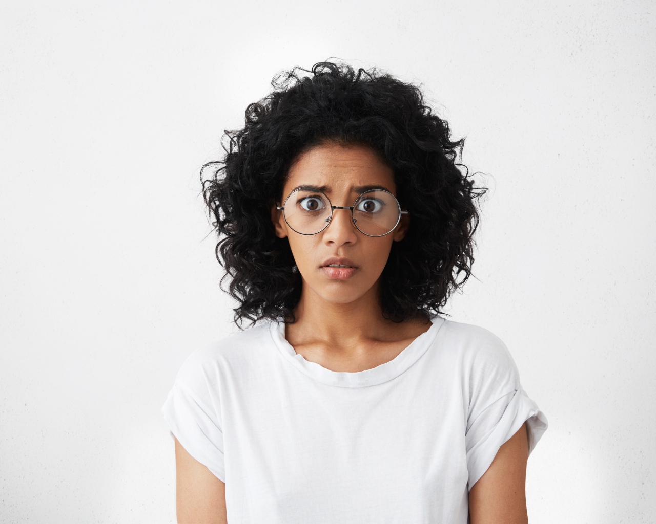 Темноволосая девушка в белой футболке на сером фоне