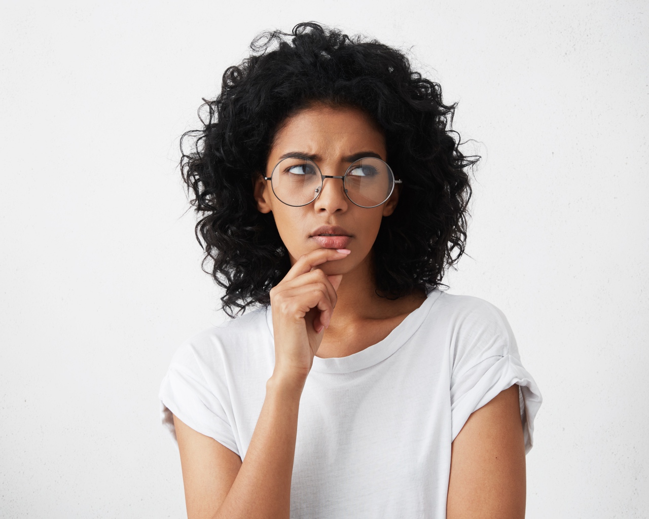 Темноволосая девушка в очках на сером фоне