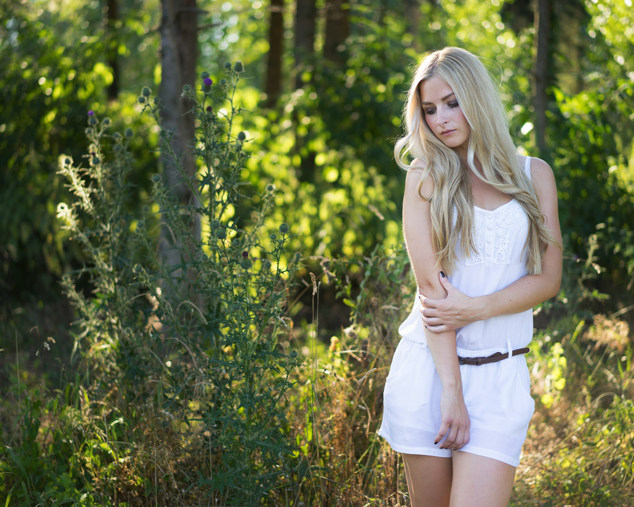 Нежная блондинка в белом костюме в лесу