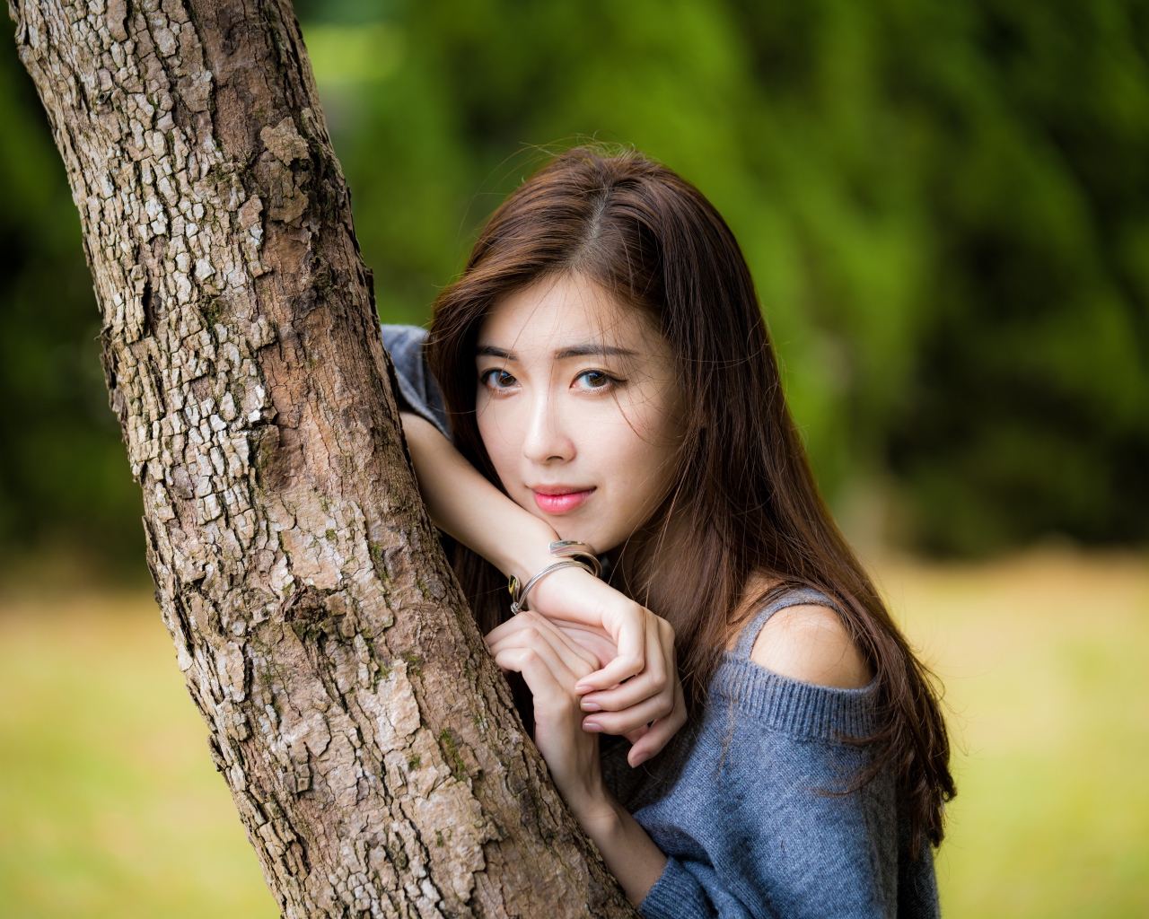 Dreamy Asian girl stands by the tree