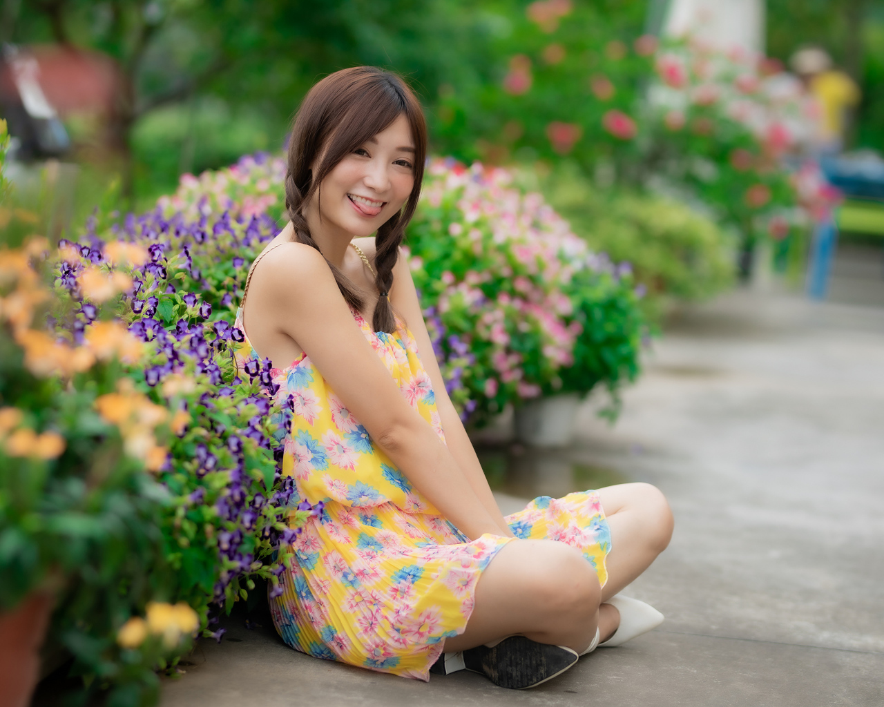 Смешная девушка азиатка в платье сидит на земле